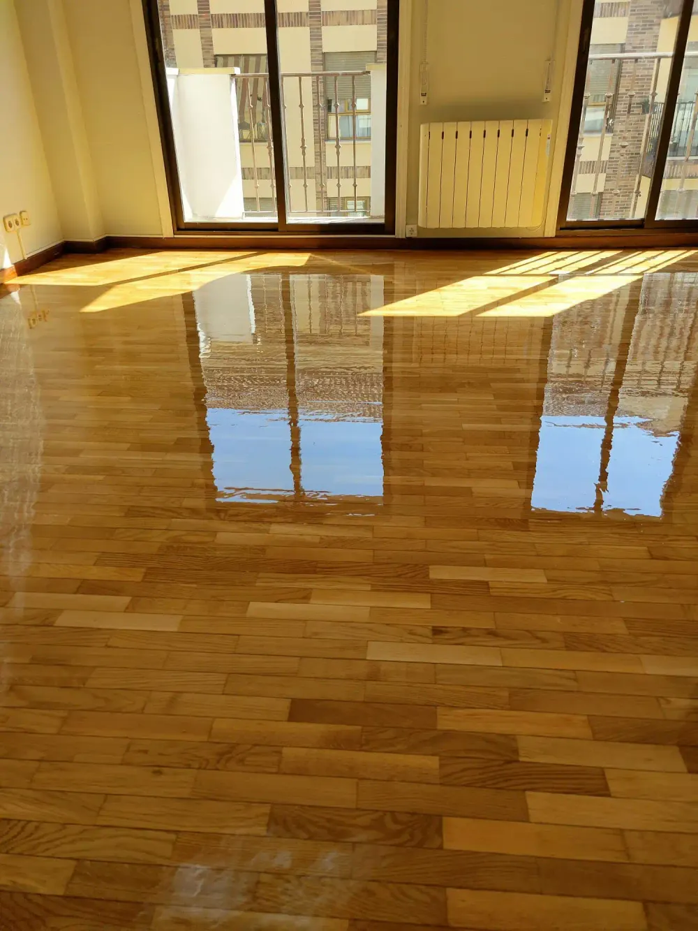 Parquet barnizado reflejando la luz natural de la ventana