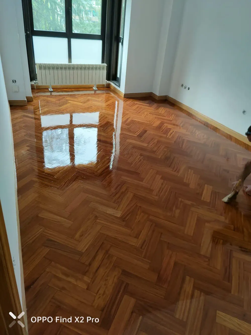 Habitación con parquet en espiga barnizado y radiador bajo la ventana