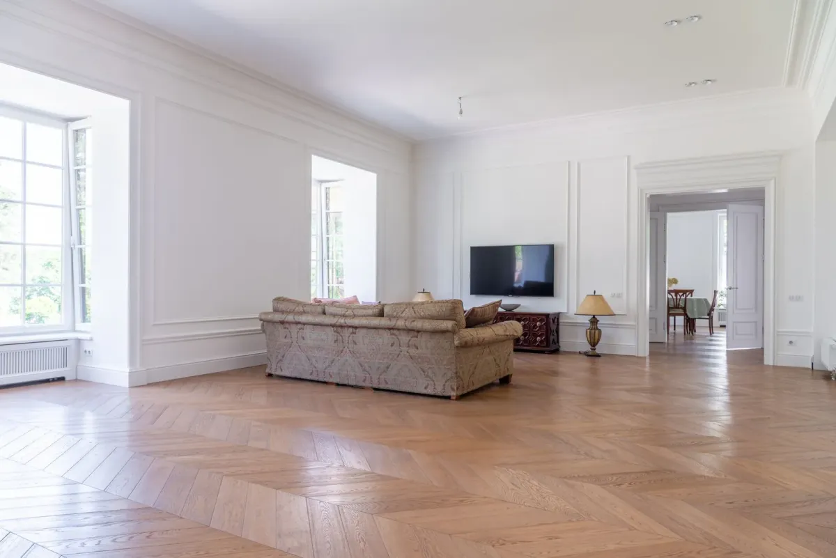 Salón amplio y luminoso con suelo de parquet en espiga de madera natural